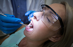 Relaxed woman receiving dental exam before T  M J therapy