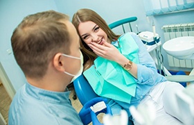 girl covering her mouth in dental chair fearful of dental x-rays