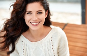 Woman with tooth colored fillings smiling outside 