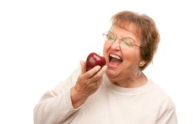 Older woman biting an apple