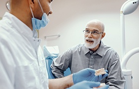 Older man asking dental implant dentist in DeLand about dental implants