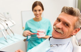 Smiling man with dentures in dental office