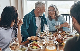 older couple laughing at dinner table 