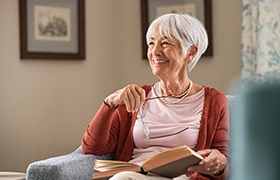 older woman smiling while sitting on couch 