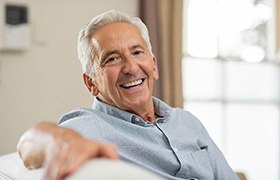 man smiling while sitting on couch