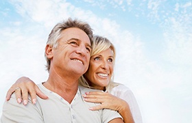 Older couple with dentures in DeLand smiling into distance