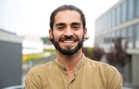 a smiling person standing on a balcony after dental implant failure and salvage