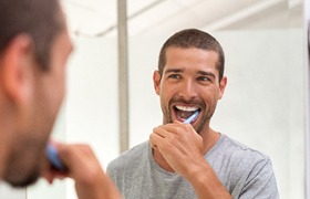 Man brushing as part of his dental implant care in Deland