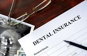 Dental insurance paperwork and glasses