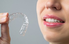 Patient holding Invisalign tray crafted using itero digital impressions