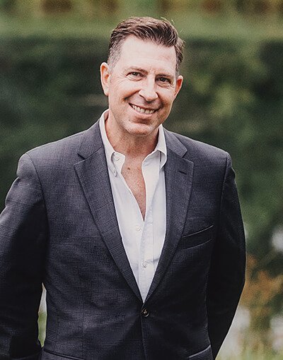DeLand dentist Doctor Christopher J Cowell smiling in a suit outdoors
