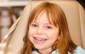 Smiling young girl in dental chair for pediatric dentistry