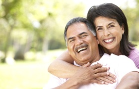 Smiling couple with dental implant-retained dentures in DeLand