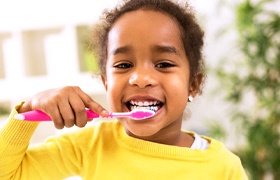 Child with dental sealants brushing teeth