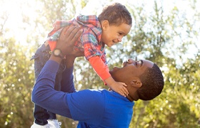 Parent lifting child into the air after dental sealant treatment visit