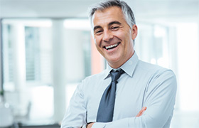 Professionally dressed man with porcelain veneers smiling