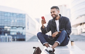 Person smiling and looking at their phone after teeth whitening