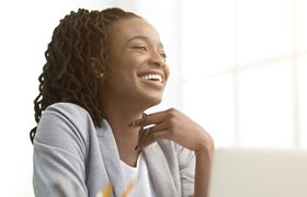 person smiling and looking out a window after zoom teeth whitening treatment