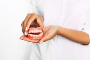 woman holding dentures