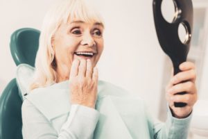 Woman admiring her new dentures in Deland