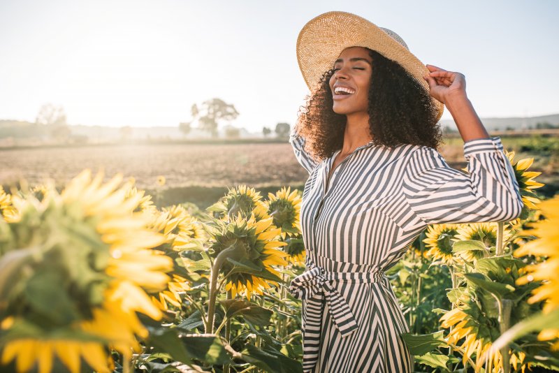 woman smiling in sunflower field during summer