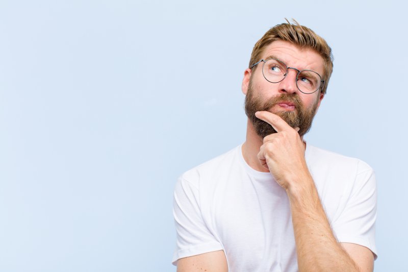 Man confused by the difference between partial dentures and dental bridges