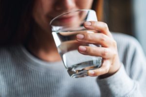 closeup of a person holding a glass of water