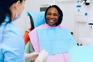 Smiling female patient speaking with dentist