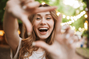 Woman forming a box around her smile with her hands