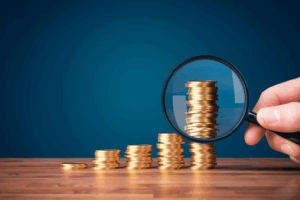 Person inspecting several coin stacks with a magnifying glass