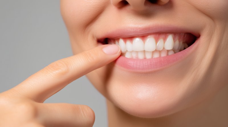 person pointing toward their front teeth